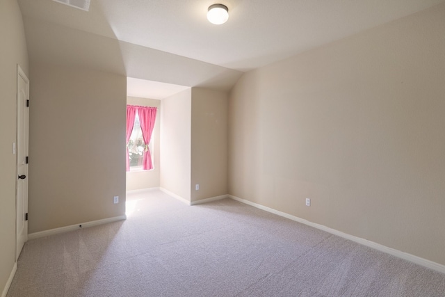 carpeted empty room featuring lofted ceiling