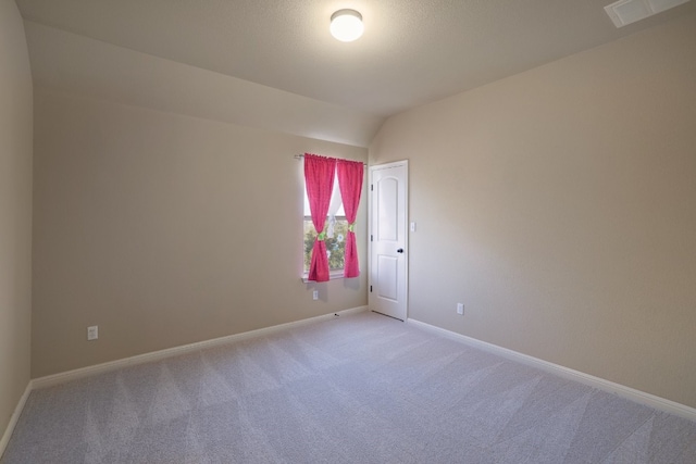 unfurnished room with lofted ceiling and light carpet