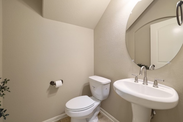 bathroom with vaulted ceiling, sink, and toilet