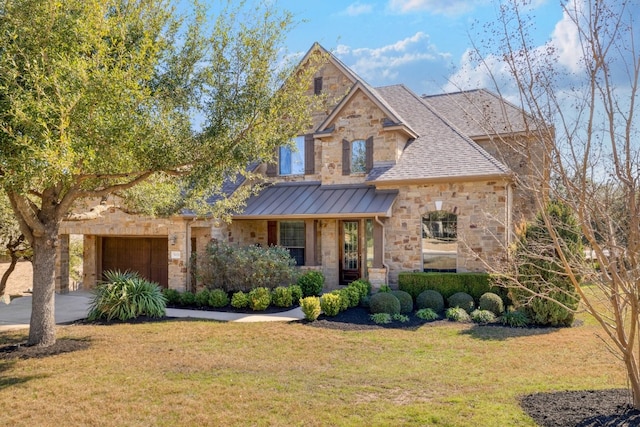 5025 Patagonia Pass, Austin, TX 78738 - view of front of home with stone siding, a front lawn, an attached garage, a standing seam roof, and driveway