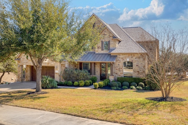 5025 Patagonia Pass, Austin, TX 78738 - view of front of home with stone siding, a standing seam roof, a front yard, driveway, and an attached garage