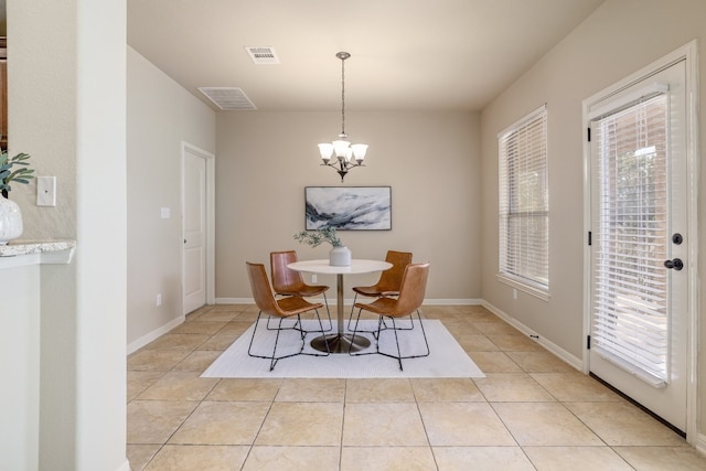 dining area with light tile patterned flooring, a chandelier, and a wealth of natural light