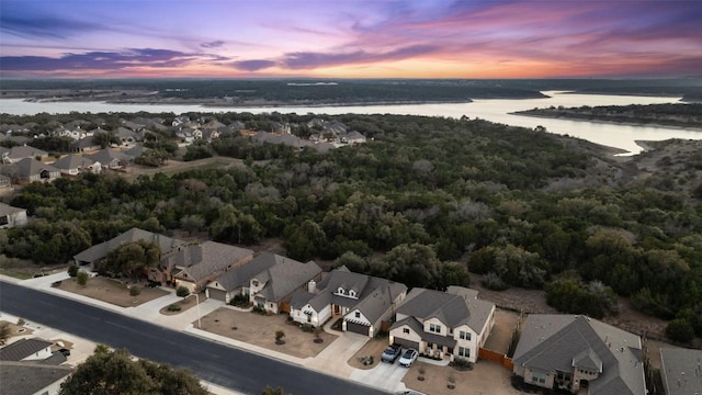 aerial view at dusk featuring a water view