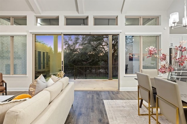 interior space with hardwood / wood-style flooring, a wealth of natural light, a notable chandelier, and beam ceiling