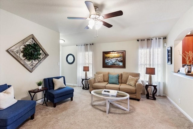 living room featuring light carpet, plenty of natural light, and ceiling fan