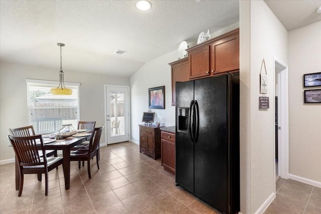 kitchen with light tile patterned flooring, black fridge with ice dispenser, vaulted ceiling, and hanging light fixtures