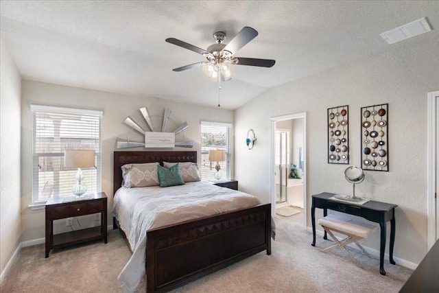 bedroom with light carpet, ensuite bath, lofted ceiling, and ceiling fan