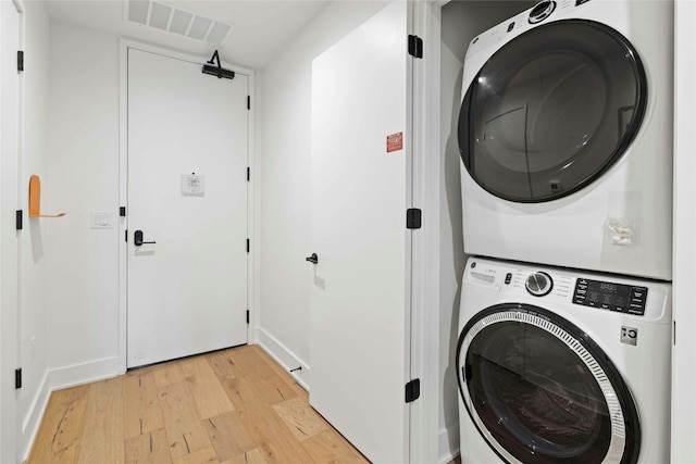 washroom featuring stacked washer / drying machine and light wood-type flooring