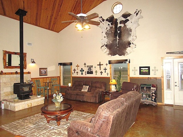 living room featuring ceiling fan, a wood stove, wooden ceiling, and high vaulted ceiling