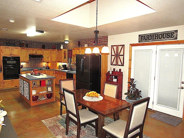 dining space with sink, a textured ceiling, and brick wall