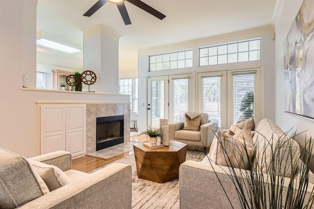 living room with light wood-type flooring, ceiling fan, and a fireplace