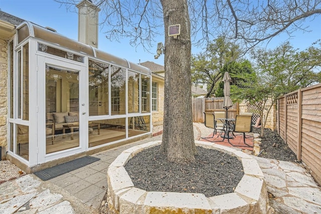 view of yard with a sunroom, a fenced backyard, and a patio