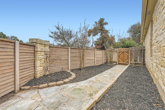 view of yard featuring a fenced backyard and a gate