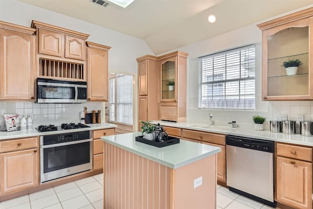 kitchen featuring stainless steel appliances, light brown cabinets, and light countertops