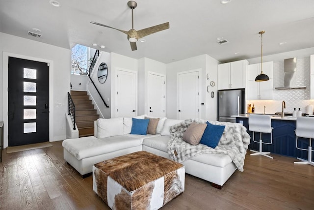 living room featuring dark hardwood / wood-style floors, sink, and ceiling fan