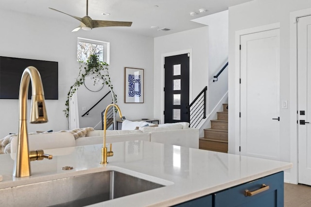 kitchen with sink, ceiling fan, and blue cabinets