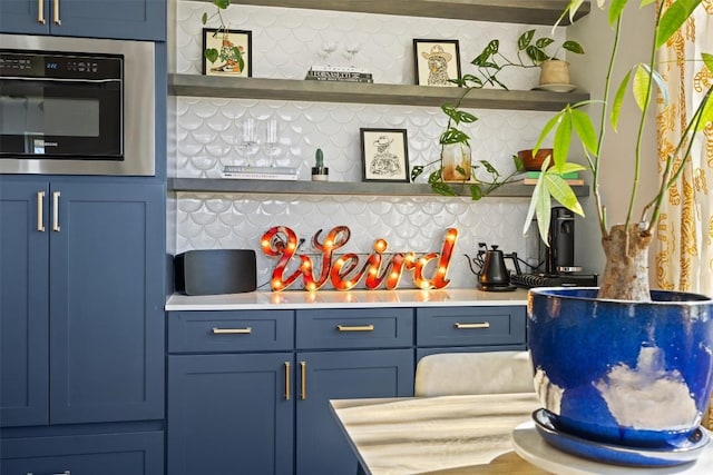 bar with blue cabinetry, oven, and decorative backsplash