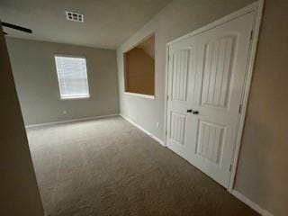 unfurnished room with a barn door and carpet