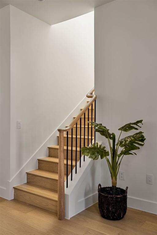 stairs featuring hardwood / wood-style floors