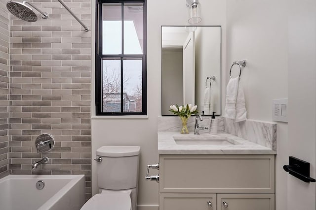 full bathroom featuring vanity, tiled shower / bath combo, and toilet