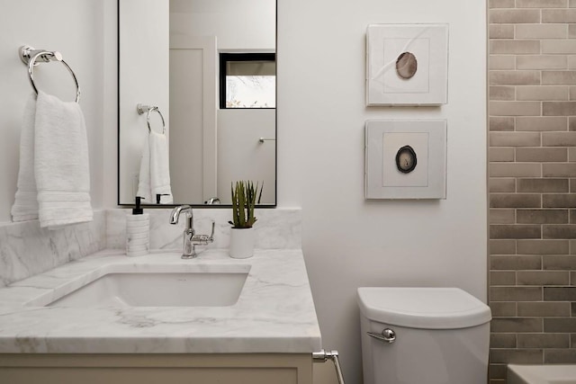 bathroom with vanity, a bathtub, and toilet