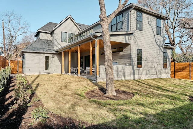 rear view of house with a lawn and a patio