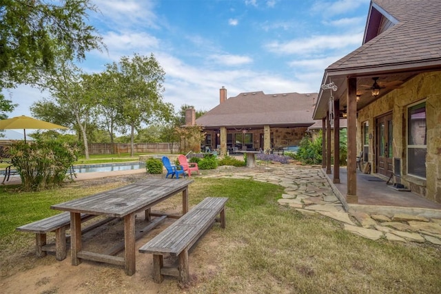 view of yard with a fenced in pool, a patio, and ceiling fan