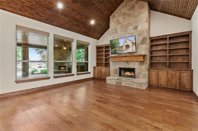 unfurnished living room featuring a stone fireplace, hardwood / wood-style floors, and wood ceiling