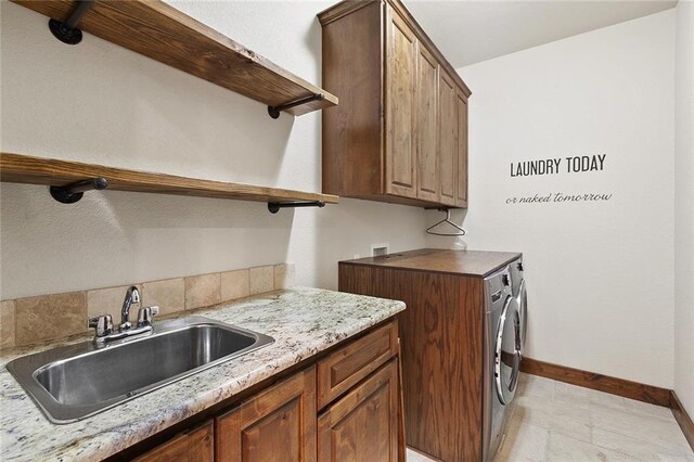 laundry area featuring cabinets, separate washer and dryer, and sink