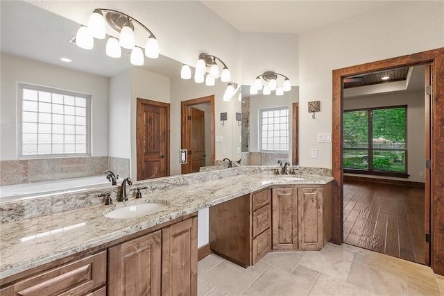 bathroom with vanity, a bath, and tile patterned floors