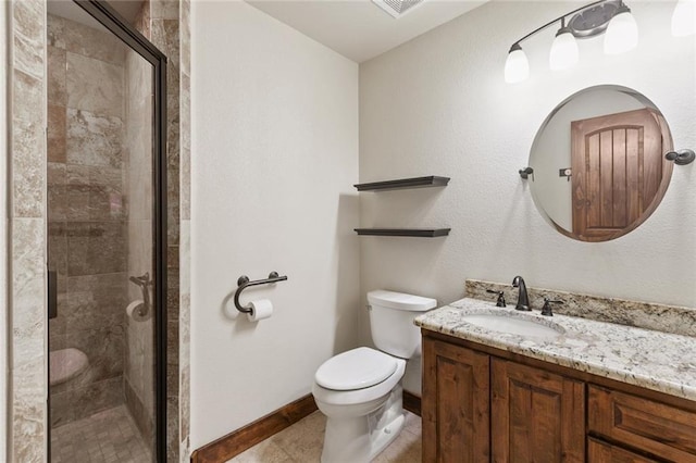 bathroom featuring tile patterned floors, vanity, toilet, and a shower with door