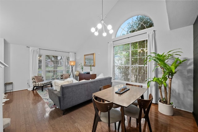 dining space featuring high vaulted ceiling, a chandelier, hardwood / wood-style floors, and a wealth of natural light