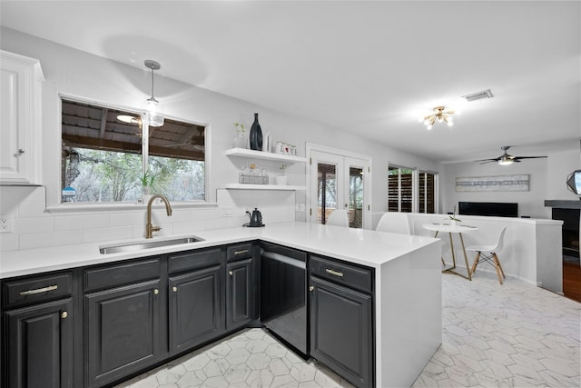 kitchen featuring sink, dishwasher, ceiling fan, tasteful backsplash, and kitchen peninsula