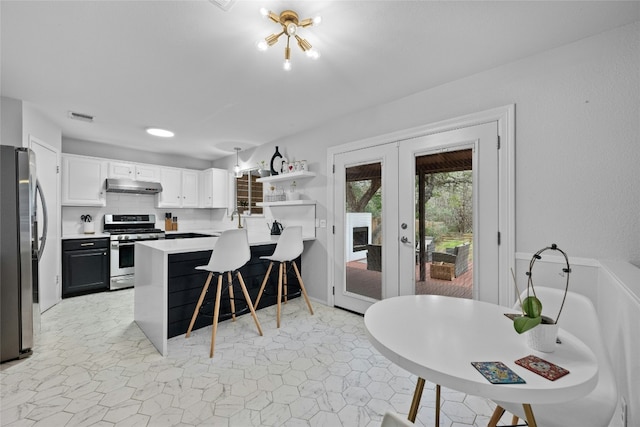 kitchen featuring white cabinetry, a kitchen breakfast bar, decorative backsplash, kitchen peninsula, and stainless steel appliances