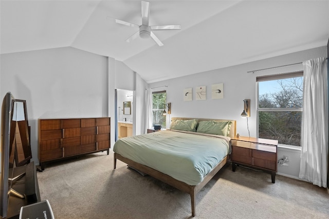 bedroom with vaulted ceiling, carpet, ensuite bathroom, and ceiling fan