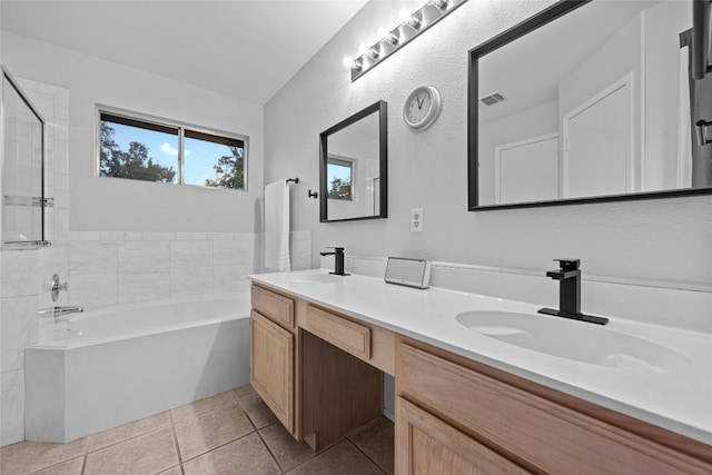 bathroom featuring tile patterned flooring, vanity, and a tub