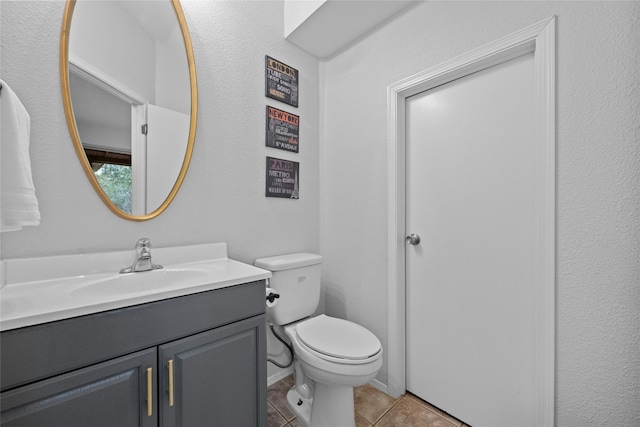 bathroom featuring tile patterned flooring, vanity, and toilet