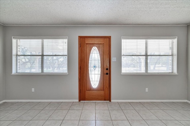 foyer entrance with light tile patterned flooring and a textured ceiling