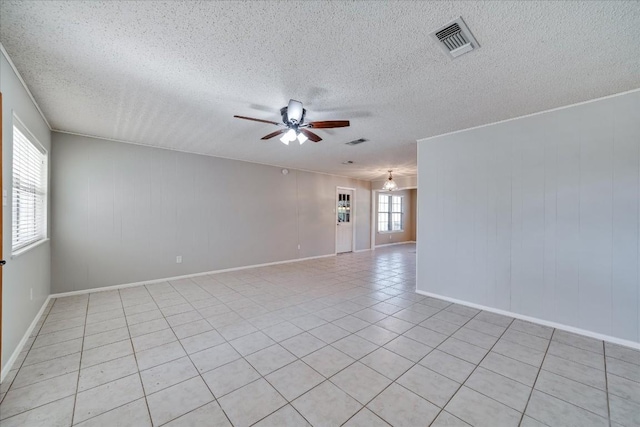 tiled spare room featuring a textured ceiling and ceiling fan