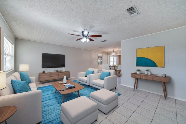 tiled living room featuring ceiling fan and a textured ceiling