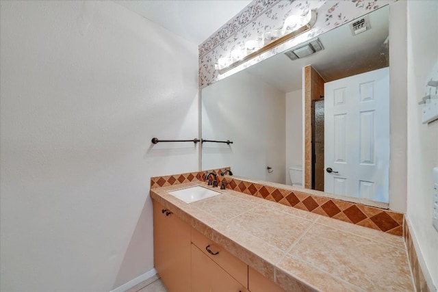 bathroom with vanity, toilet, and decorative backsplash