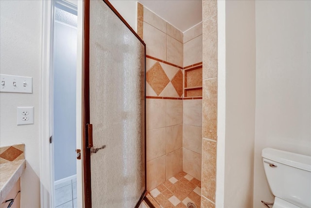 bathroom with toilet and a tile shower