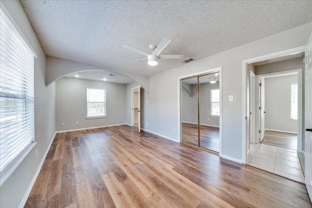 unfurnished room featuring ceiling fan, a textured ceiling, and light wood-type flooring