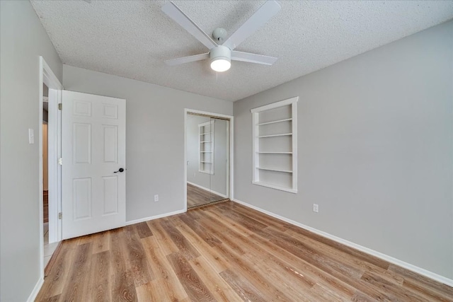 unfurnished bedroom with ceiling fan, light hardwood / wood-style floors, a closet, and a textured ceiling