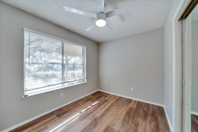 empty room featuring ceiling fan, hardwood / wood-style floors, and a textured ceiling