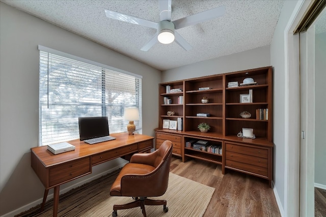 office area featuring hardwood / wood-style flooring, ceiling fan, and a textured ceiling