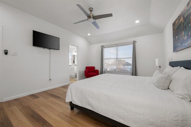 bedroom featuring lofted ceiling, hardwood / wood-style floors, connected bathroom, and ceiling fan