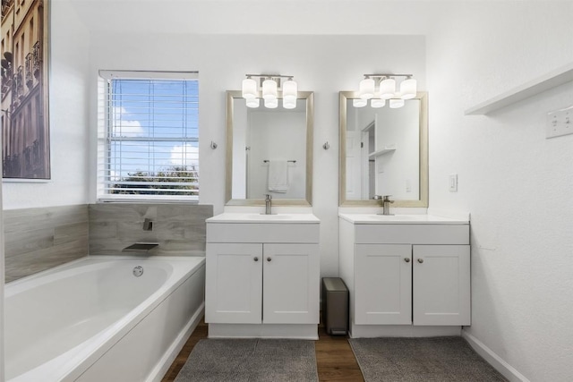 bathroom with vanity, wood-type flooring, and a bathtub