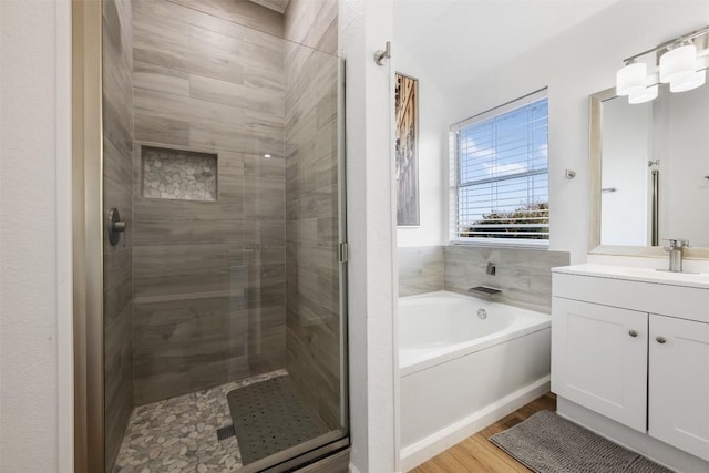 bathroom with vanity, shower with separate bathtub, and hardwood / wood-style floors