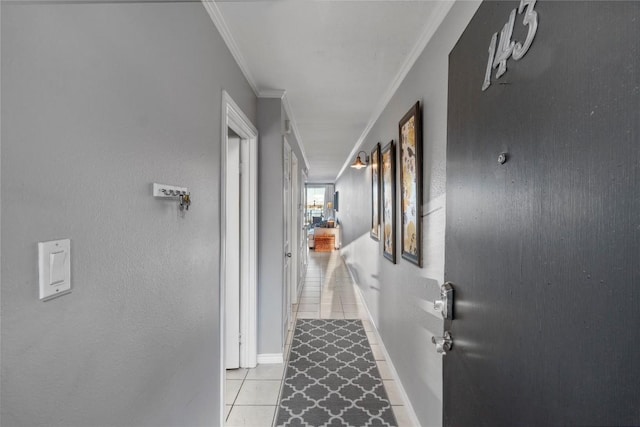 hall featuring light tile patterned floors and crown molding